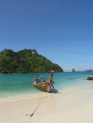 Long tail boat on an island in Phang nga Bay in Thailand by Gordana Zdjelar 